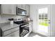 Modern kitchen featuring grey cabinets, granite countertops, stainless steel appliances, and a door to the backyard at 3148 Ora Smith Rd, Lincolnton, NC 28092