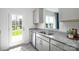 Bright kitchen featuring grey cabinets, granite countertops, stainless steel appliances, and a door to the backyard at 3148 Ora Smith Rd, Lincolnton, NC 28092