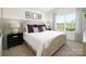 A staged main bedroom features a large window and decorative pillows at 3148 Ora Smith Rd, Lincolnton, NC 28092