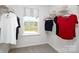 Walk-in closet featuring carpeted floor, window view, wire shelving, and hanging clothes with neutral colored walls at 3156 Ora Smith Rd, Lincolnton, NC 28092