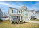 Two-story light green house with a front porch and landscaping at 3836 Lake Breeze Dr, Sherrills Ford, NC 28673