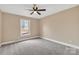 Unfurnished bedroom features neutral walls, plush carpet, a ceiling fan, and a window for natural light at 407 Thomas St, Marshville, NC 28103