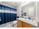 Neat bathroom with shower/tub combo, wood vanity, and updated fixtures at 4210 Saguaro Ct, Charlotte, NC 28269