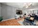 Living room with gray walls, wood floors, and a large TV at 4210 Saguaro Ct, Charlotte, NC 28269