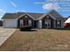 Brick and gray siding ranch home with a spacious lawn at 4630 Sw Falcon Chase Sw Dr, Concord, NC 28027