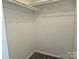 Spacious closet with wood shelving and hanging rod at 4902 Spring Lake Dr # E, Charlotte, NC 28212