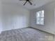 Bedroom with gray carpet and vaulted ceiling, featuring a ceiling fan at 6411 Windsor Gate Ln, Charlotte, NC 28215