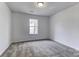 Well-lit bedroom featuring gray carpet and a window at 6411 Windsor Gate Ln, Charlotte, NC 28215