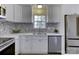 Renovated kitchen with white shaker cabinets and mosaic backsplash at 6411 Windsor Gate Ln, Charlotte, NC 28215