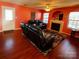 Living room with fireplace, hardwood floors, and leather furniture at 8024 Bronze Pike Dr, Charlotte, NC 28273