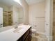 Well-lit bathroom featuring a large mirror, single sink vanity, and a tiled walk-in shower at 9029 Treetop Nw Way, Concord, NC 28027