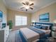 This staged bedroom features a tray ceiling, a ceiling fan, and sophisticated decor, exuding style and comfort at 9029 Treetop Nw Way, Concord, NC 28027