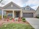 Charming single Gathering home with a brick and siding facade, two-car garage, and a landscaped front yard at 9029 Treetop Nw Way, Concord, NC 28027