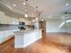 Bright kitchen with granite countertops, stainless steel appliances, bar stool seating and hardwood floors at 9029 Treetop Nw Way, Concord, NC 28027