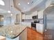 Well-lit kitchen showcases a large island with granite countertop and stainless steel appliances at 9029 Treetop Nw Way, Concord, NC 28027