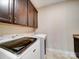 Bright laundry room with modern washer and dryer units and overhead cabinets at 9029 Treetop Nw Way, Concord, NC 28027