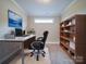 Office featuring a modern desk, chair, shelving, and a serene ocean view art piece at 9029 Treetop Nw Way, Concord, NC 28027