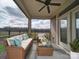 Cozy porch setup with a wicker sofa and chair with blue pillows, plus glass top table at 9029 Treetop Nw Way, Concord, NC 28027