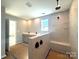 An unfinished bathroom with a double sink vanity, and a tiled shower with a bench seat at 9934 Cask Way, Huntersville, NC 28078