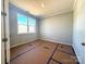 Unfurnished bedroom showing neutral walls and trim, a window, and flooring partially protected during construction at 9934 Cask Way, Huntersville, NC 28078