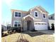 Charming two-story home featuring stone accents, a two-car garage, and a well-manicured lawn at 9934 Cask Way, Huntersville, NC 28078