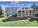 This home's backyard features lush grass and a screened-in porch with airy architecture at 10433 Pullengreen Dr, Charlotte, NC 28277