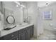 Bright bathroom with a decorative mirror, gray vanity, and shower at 10433 Pullengreen Dr, Charlotte, NC 28277