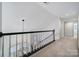 Upstairs hallway boasts updated railing and banister, and modern light fixture at 10433 Pullengreen Dr, Charlotte, NC 28277