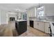 Open kitchen with stainless steel appliances, white cabinets and a view to the fireplace in the living room at 10433 Pullengreen Dr, Charlotte, NC 28277