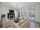 Bright living room features a fireplace, modern light fixture, and access to a patio through glass doors at 10433 Pullengreen Dr, Charlotte, NC 28277