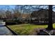 View of the community pool and pool house with manicured landscaping and mature trees on a sunny day at 10904 Pimlico Dr, Charlotte, NC 28273