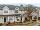 Tan two-story townhome with a covered porch and landscaping at 12250 Savannah Garden Dr, Charlotte, NC 28273