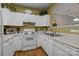 White kitchen with wood flooring, ample counter space, and appliances at 12250 Savannah Garden Dr, Charlotte, NC 28273