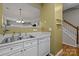 White kitchen with double sink and dishwasher, near staircase at 12250 Savannah Garden Dr, Charlotte, NC 28273