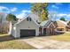 View of the house featuring the garage, partial brick, and lawn with bare trees at 12527 Cedar Post Ln, Charlotte, NC 28215