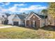 Low angle of the house showing the garage, partial brick, and front lawn at 12527 Cedar Post Ln, Charlotte, NC 28215