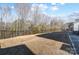 Large fenced backyard with dry grass, leading up to a wooded area for privacy at 1328 Lena St, Monroe, NC 28112