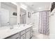 Bright bathroom features a double sink vanity, a large mirror, and tub with shower combo at 1328 Lena St, Monroe, NC 28112