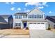 Charming two-story home with a blue front door, shuttered windows, and a two-car garage at 1328 Lena St, Monroe, NC 28112