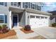 Close-up of the home's entryway, showcasing a blue front door and a two-car garage at 1328 Lena St, Monroe, NC 28112