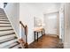 Hallway view with hardwood floors, stairs with wooden handrail, and white trim at 1328 Lena St, Monroe, NC 28112