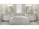 Large bathroom with double vanity and a luxurious soaking tub at 13308 Oak Farm Ln, Huntersville, NC 28078