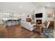 Open living room and kitchen with hardwood floors, fireplace, and vaulted ceilings at 13308 Oak Farm Ln, Huntersville, NC 28078