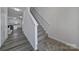 Modern staircase with gray carpeting and wood floors at 176 Briana Marie Way, Indian Trail, NC 28079