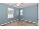 Blue-walled bedroom with ceiling fan and large window at 201 Waterlynn Ridge Rd # E, Mooresville, NC 28117