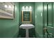 Small powder room with pedestal sink and green walls at 2228 Valencia Ter, Charlotte, NC 28226