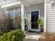 Inviting front entry with a glass door, landscaping, and white columns at 2262 Galloway Sw Ln, Concord, NC 28025