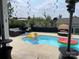 Backyard pool area with outdoor seating, umbrella, and fun floatation devices under a partly cloudy sky at 2262 Galloway Sw Ln, Concord, NC 28025