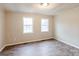 Simple bedroom with wood-look flooring and two windows at 2331 Celia Ave, Charlotte, NC 28216