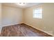 Small bedroom with wood-look flooring and a single window at 2331 Celia Ave, Charlotte, NC 28216